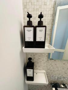 three bottles of soap sitting on a shelf in a bathroom at つんまぁー家 in Miyakojima +22 photos