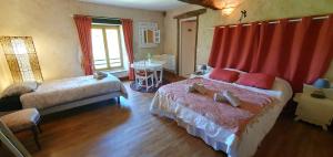 a bedroom with two beds and a table with a window at La Grande Vesvre in Gigny +12 photos