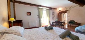 a bedroom with a bed and a table in a room at La Grande Vesvre in Gigny