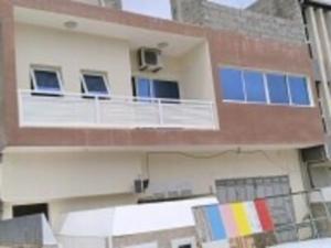 a building with a balcony with a flag on it at Monte Do Bem-Estar Tarrafal in Tarrafal
