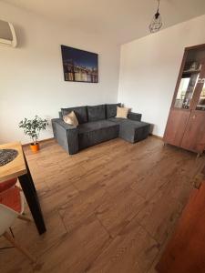 a living room with a couch and a wooden floor at APARTAMENT MARTA in Biłgoraj