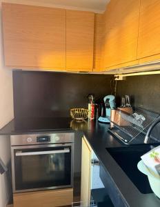 a kitchen with a stainless steel oven and wooden cabinets at Agde centre historique avec vue in Agde