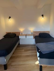 two beds in a room with lights on the wall at Agde centre historique avec vue in Agde