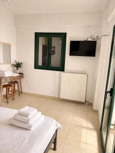 a room with a bed and a tv and a table at Zen Villas in Nikiana