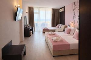 a large hotel room with two beds and a couch at Hotel Ancora Beach in Primorsko +63 photos