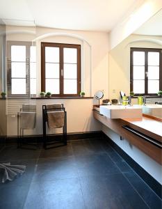 a large bathroom with two sinks and two mirrors at Pension Donatus in Pirna +84 photos