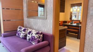 a purple couch in a room with a kitchen at Asenata Apartament 46m2 Ustroń Centrum in Ustroń