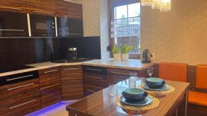 a kitchen with a wooden table with two plates on it at Asenata Apartament 46m2 Ustroń Centrum in Ustroń