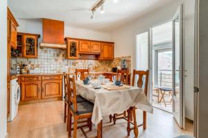 a kitchen with a table and chairs and a kitchen with wooden cabinets at Maison proche Vaison la Romaine in Saint-Romain-en-Viennois