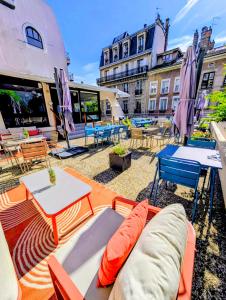 a patio with a couch and tables and chairs at ibis Grenoble Centre Bastille in Grenoble