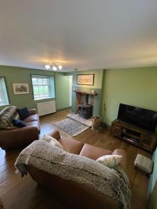 a living room with a couch and a fireplace at Delightful detached 2 bedroom cottage in Grantley +5 photos