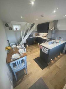 a kitchen with a sink and a staircase in a room at Delightful detached 2 bedroom cottage in Grantley