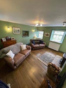 a living room with two couches and a couch at Delightful detached 2 bedroom cottage in Grantley