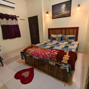 a bedroom with a large bed with pink roses on it at Hotel B B Pride in Raipur