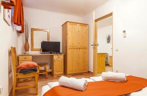 a room with two beds and a desk with a television at Apartman Levendula in Balatonfüred