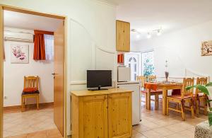 a kitchen and living room with a tv and a table at Apartman Levendula in Balatonfüred