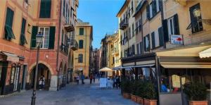 a street with buildings and people walking down a street at Casa Conchiglia 6 ospiti 5 minuti a piedi da mare, centro e stazione comfort completo in Rapallo