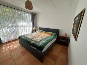 a bedroom with a bed in a room with a window at Finca Las Flores in El Cedro