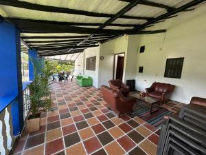 a living room with couches and chairs on a tile floor at Finca Las Flores in El Cedro