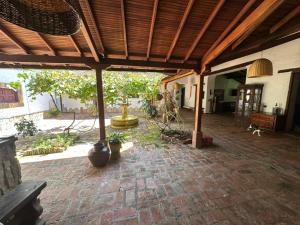 an outdoor patio with a wooden roof and a stone floor at Finca Las Flores in El Cedro