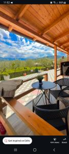 a patio with a table and chairs and a roof at Olive Oasis Studio in Berat