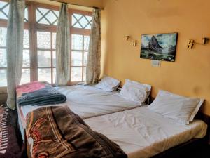 a bedroom with two beds in front of a window at T-Suru Hotel & Cafe Leh in Leh