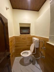 a bathroom with a white toilet in a room at Nature Nest in Manāli
