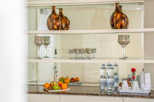 a kitchen counter with bottles and glasses on shelves at Plaza Inn Hotel in Doha