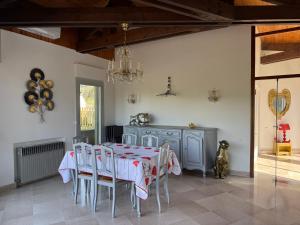 a dining room with a table and chairs and a chandelier at L'Olivada, villa d'exception in Ganges