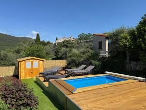a backyard with a pool and chairs and a house at L'Olivada, villa d'exception in Ganges
