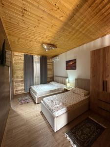 a bedroom with two beds and a wooden ceiling at Olive Oasis Studio in Berat
