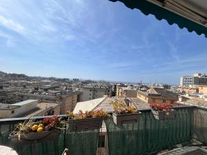 a view of a city from a balcony with potted plants at Panoramic Terrace & Sea View Flat with Free Parking in Genoa