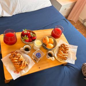 a tray with pastries and fruit on a bed at Panoramic Terrace & Sea View Flat with Free Parking in Genoa