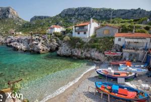 a group of boats sitting on a beach at Hercules casa in Kymi