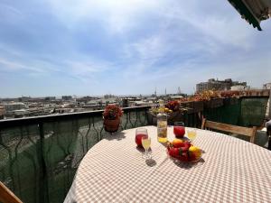 a table with glasses of wine and fruit on a balcony at Panoramic Terrace & Sea View Flat with Free Parking in Genoa
