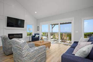 a living room with two couches and a fireplace at Beach Buzz by Oak Island Accommodations in Caswell Beach
