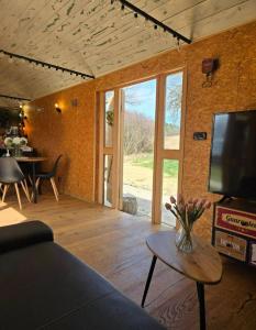 a living room with a couch and a tv and a table at Obytný vagón Bzová Běleč in Kamberk