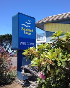a blue welcome sign in front of a building at Seabird Lodge Fort Bragg in Fort Bragg
