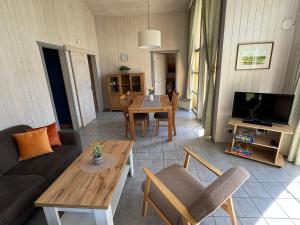 a living room with a couch and a table at Seeschwalbe 240 in Mirow