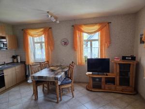 a kitchen with a table and a tv in it at Ferienwohnung in der Sächsischen Schweiz in Königstein an der Elbe
