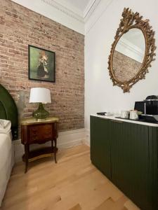 a room with a mirror and a table with a lamp at Le Chateau de Pierre in Quebec City