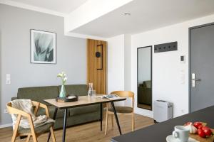 a living room with a table and a couch at appartello - smarttime living Berlin in Berlin