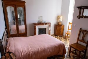 a bedroom with a bed and a fireplace at Gite de La Cueille - Chambre double in Ribes +6 photos