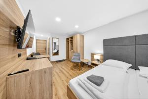 a bedroom with a bed and a desk with a television at Schinagl Klaus in Klaus an der Pyhrnbahn