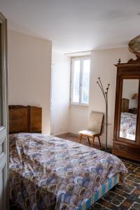 a bedroom with a bed and a chair and a mirror at Gite de La Cueille - Chambre double in Ribes