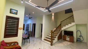 a living room with a staircase and a dining room at Bay Breeze Vijay Villa in Pondicherry