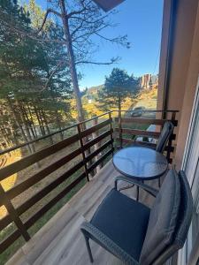 a table and chairs on a balcony with a view at Apartman Davidovic in Divčibare
