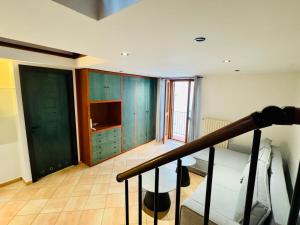 a bedroom with green cabinets and a bed and a staircase at APARTAMENT MAYA - Julia Vieste in Vieste