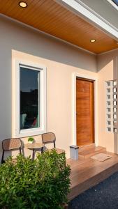 a patio with chairs and a table and a wooden door at ยินดีรีสอร์ท Yindee Resort in Don Sak