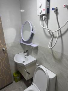 a bathroom with a toilet and a sink and a mirror at Home Transit Hulhumale' Phase 2 in Male City